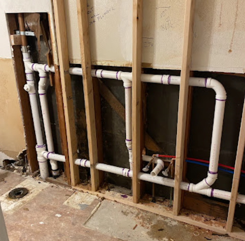 PVC rough-in plumbing inside wall framing